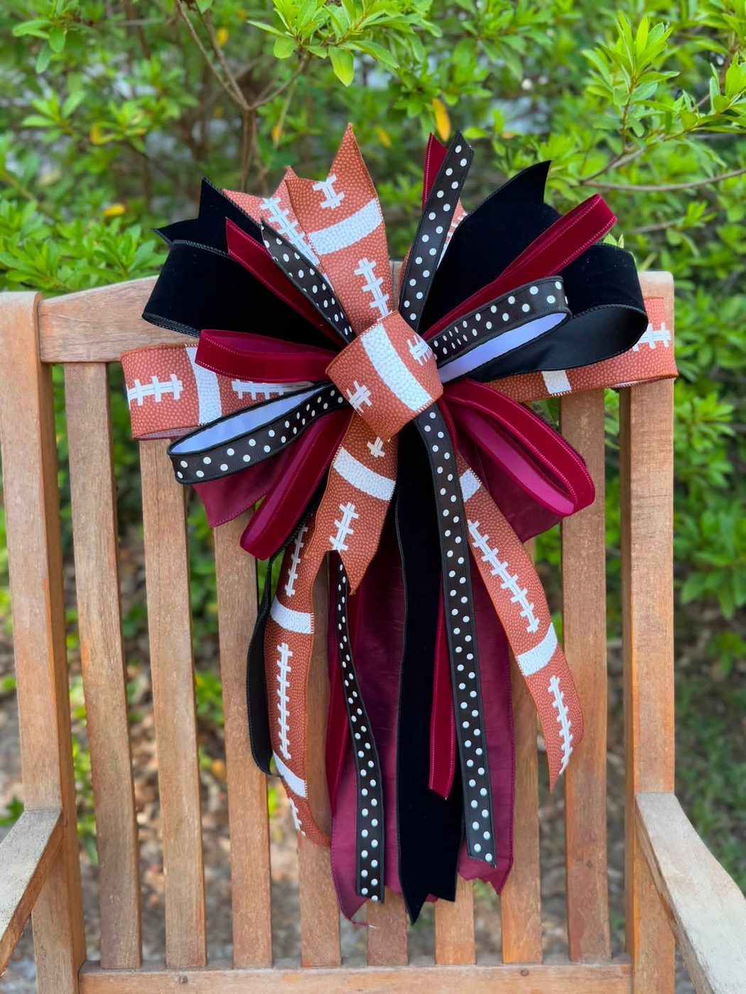 Football-print bow in garnet, black, and orange on a wooden chair