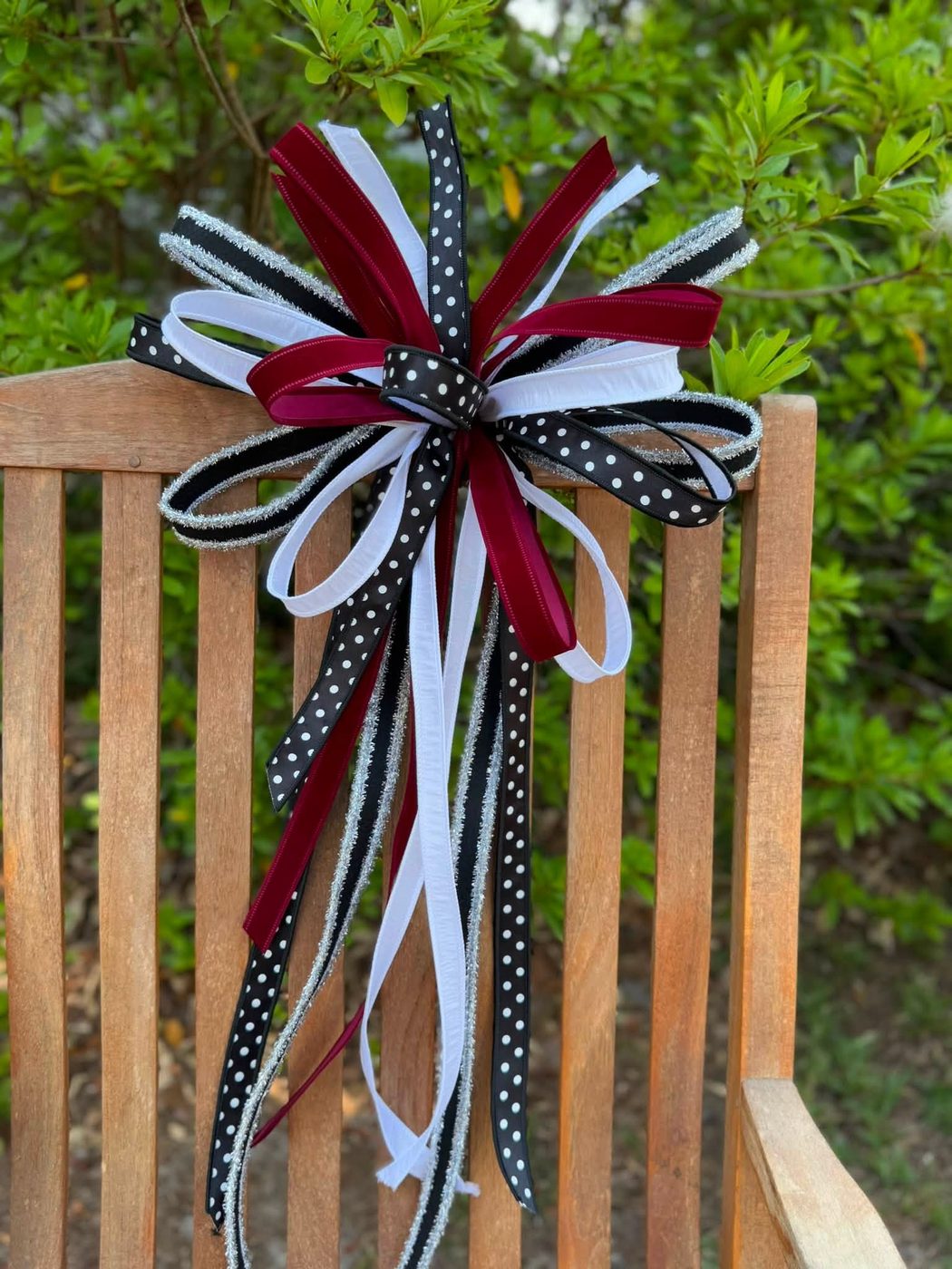 Black, white, and burgundy polka dot bow with silver tinsel ribbon