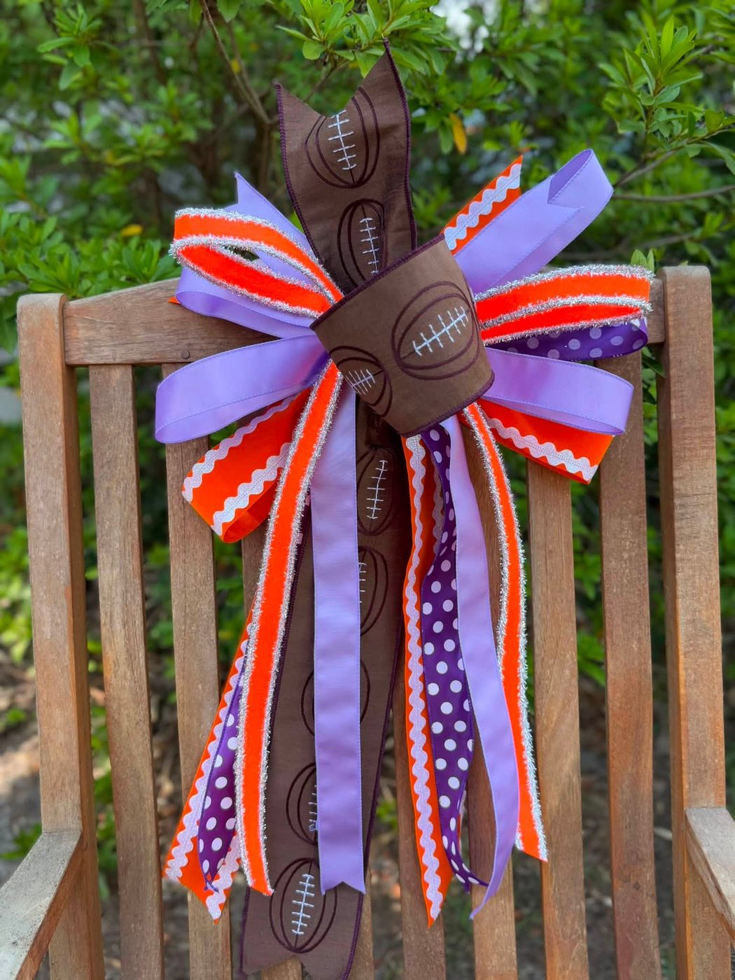 Brown football-print bow with purple and orange ribbon